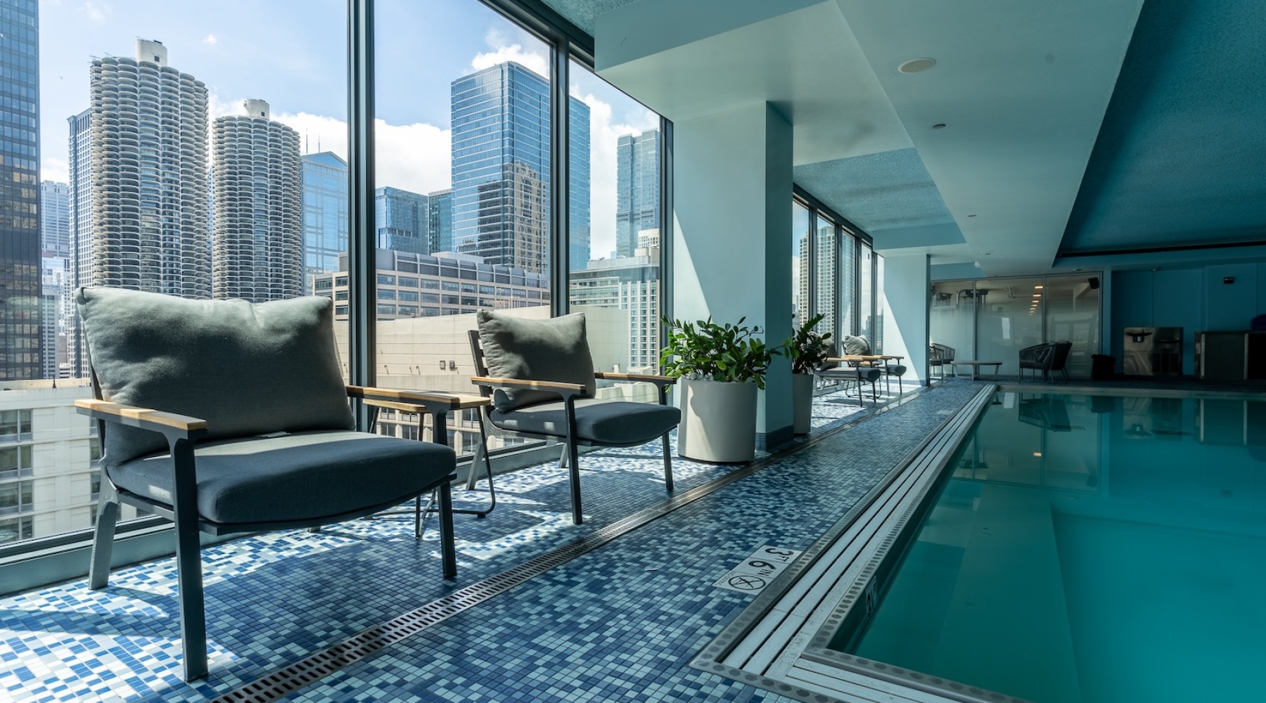 Indoor pool with lounging areas and stunning skyline views at State and Grand Chicago apartment rentals